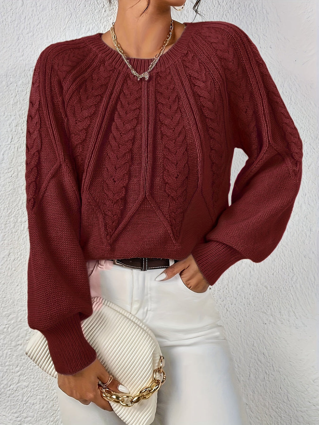 Afslappet kabelstrikket sweater, båret over bluse