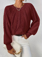 Afslappet kabelstrikket sweater, båret over bluse
