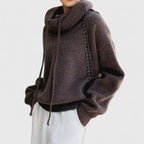 Detalje af hætten med snoretræk på den strikkede hoodie