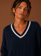 Nærbillede af kabelstrikmønsteret på den marineblå sweater