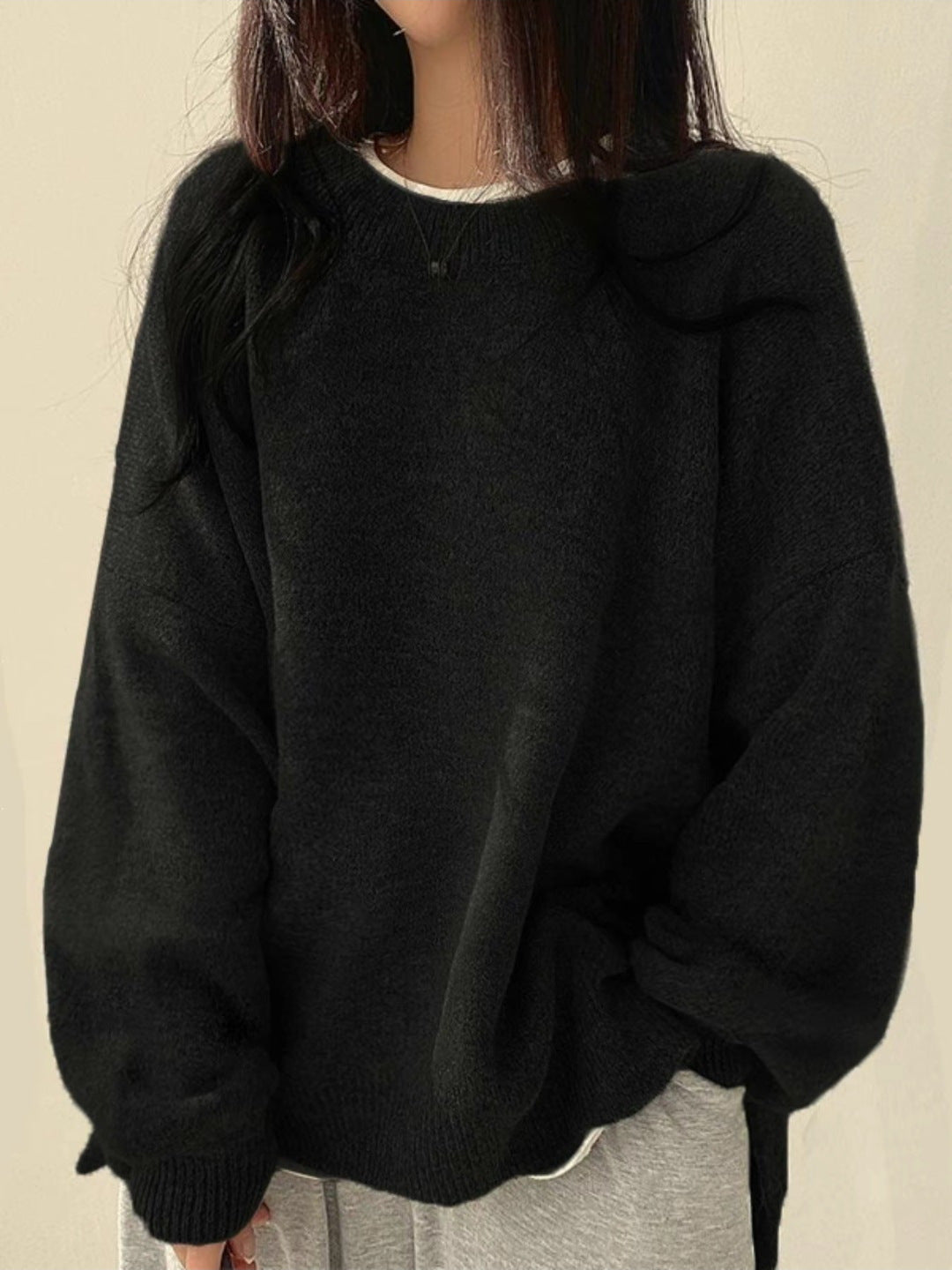 Strik-sweater med faldende skuldre, båret med jeans
